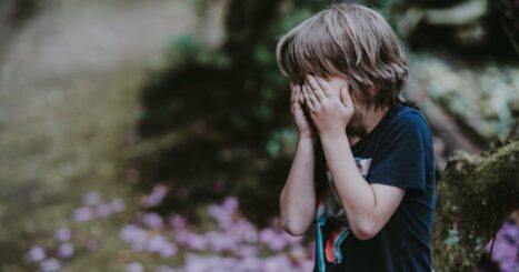 Young boy covers his eyes