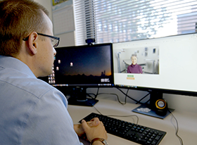 man looks at video feed on computer screen