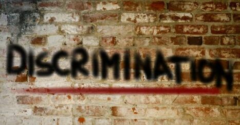 "Discrimination" spray painted on brick wall