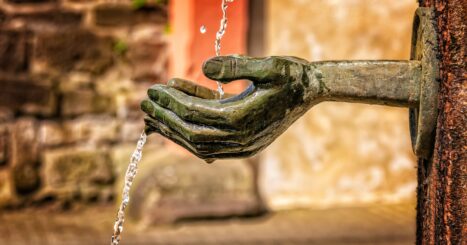 Sculpture of cupped hand with water streaming into it