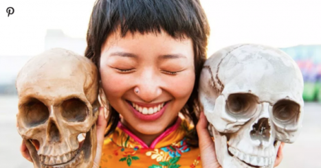 Woman smiles with two skulls