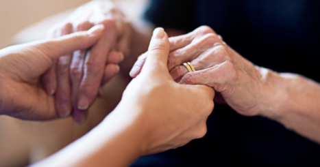 Younger hands hold elderly hands