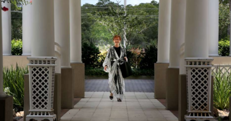 Smiling woman walks between pillars