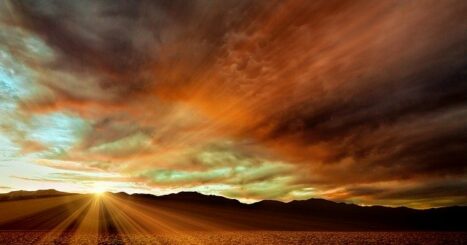 Light streams over hills at sunset