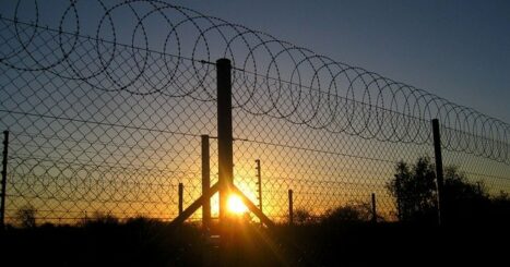 Barbed wire fence at a prison at dawn