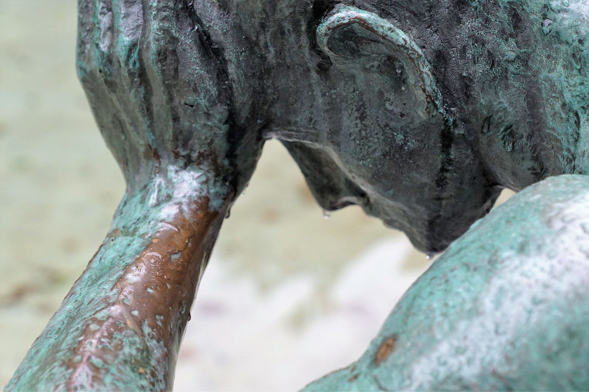 Bronze sculpture of a man with drops of water