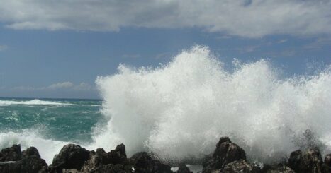 Ocean waves crash onto boulders