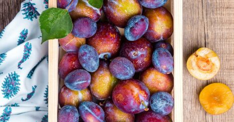 Wooden box of ripe plums