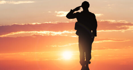 silhouette of soldier standing at attention at sunset